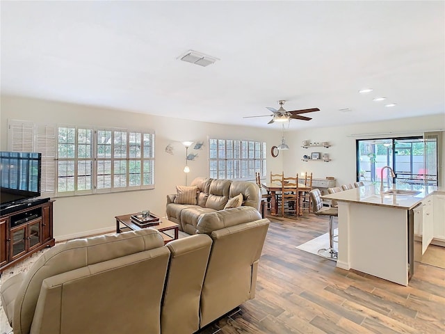 living area with a ceiling fan, recessed lighting, visible vents, and wood finished floors