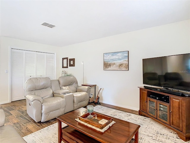 living area featuring light wood-type flooring, visible vents, and baseboards