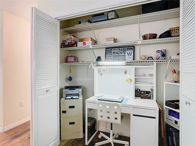 home office with baseboards and wood finished floors