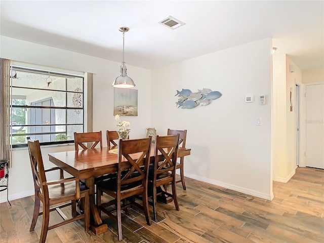 dining space with visible vents, light wood-style flooring, and baseboards