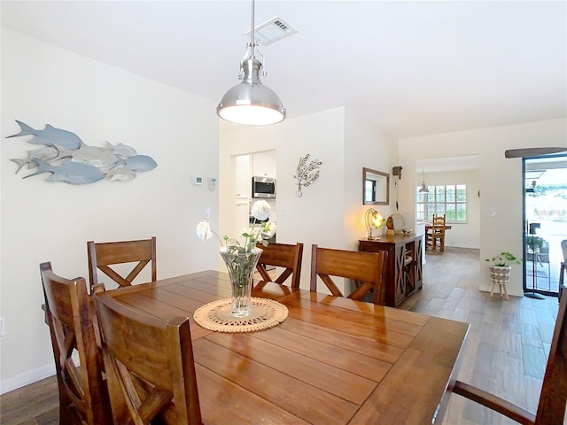 dining area featuring wood finished floors, visible vents, and baseboards