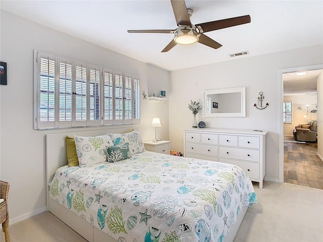 bedroom with a ceiling fan, visible vents, and baseboards