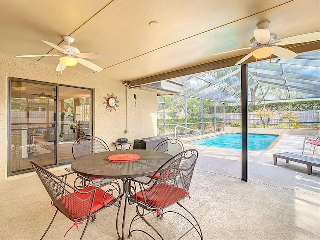 exterior space with a fenced in pool, a ceiling fan, glass enclosure, fence, and a patio area