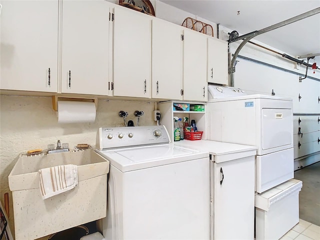 washroom featuring washing machine and dryer, cabinet space, and a sink