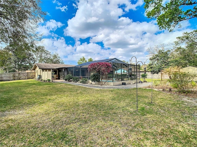 exterior space featuring a lanai, a fenced backyard, and a yard