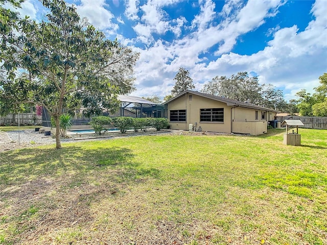 view of yard with a lanai, fence, and a fenced in pool