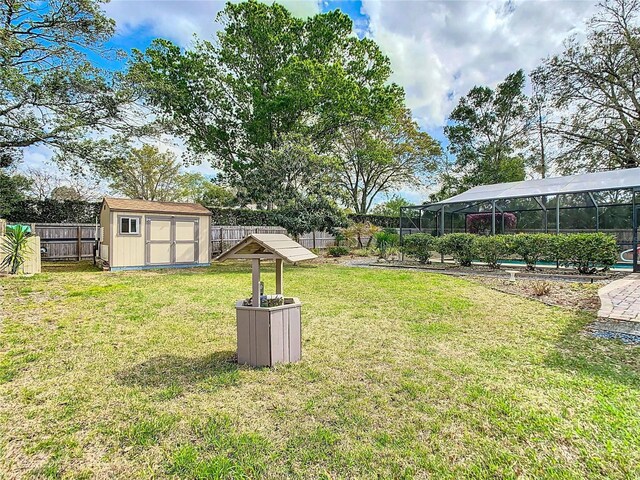 view of yard with an outbuilding, a shed, a fenced backyard, and a lanai