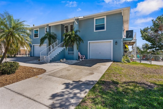 view of front of house with a garage, concrete driveway, stairs, and a gate