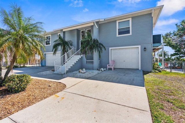 view of front of house with a garage, driveway, and stairs