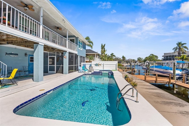 view of swimming pool featuring a dock, a pool with connected hot tub, a ceiling fan, and a patio