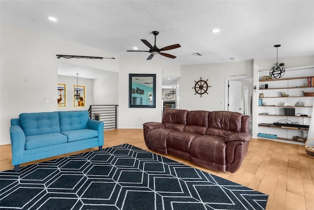 living room with a textured ceiling, wood finished floors, and recessed lighting