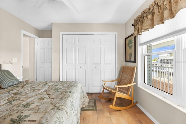 bedroom with a closet, baseboards, and wood finished floors