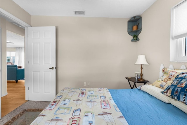 bedroom featuring visible vents and wood finished floors