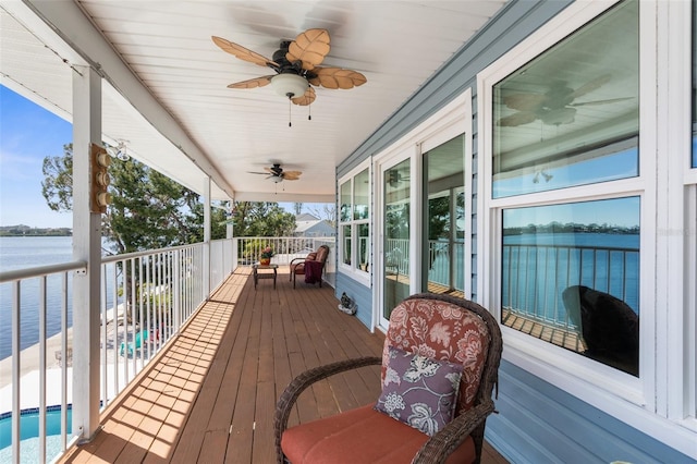 deck with a water view and ceiling fan