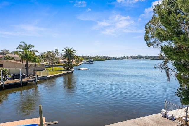 view of dock with a water view and fence