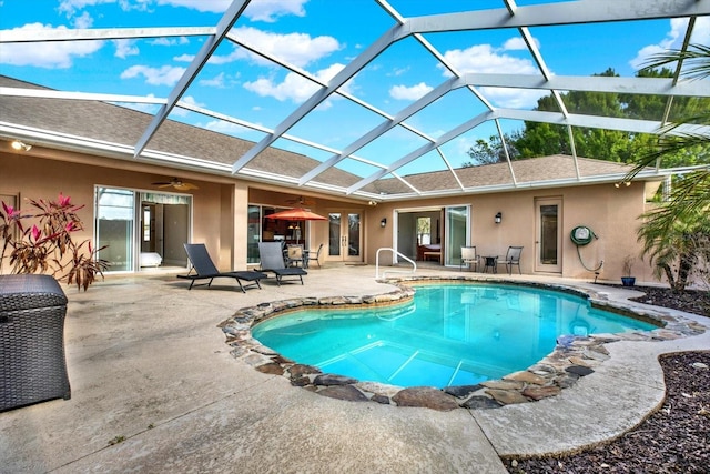 pool with glass enclosure, french doors, a patio area, and ceiling fan