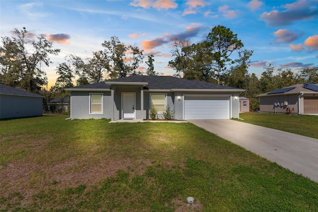 single story home with a garage, concrete driveway, a yard, and stucco siding