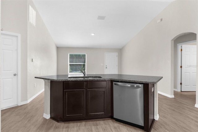 kitchen featuring light wood-style floors, arched walkways, dishwasher, and a sink