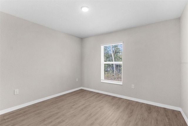 spare room with light wood finished floors and baseboards