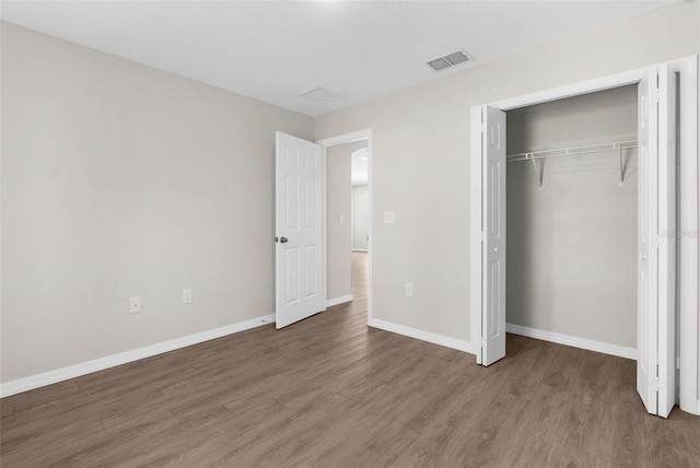 unfurnished bedroom featuring visible vents, baseboards, and wood finished floors