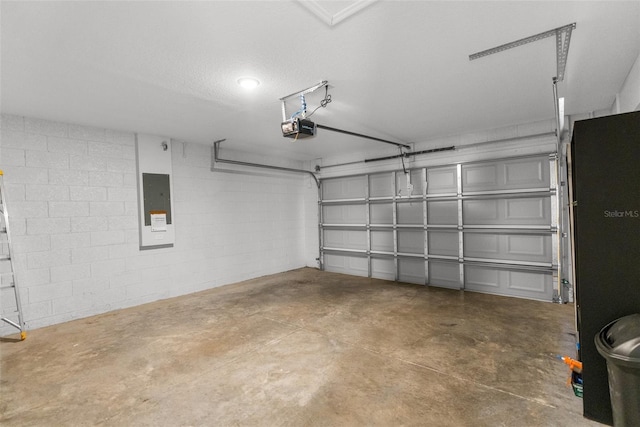 garage featuring a garage door opener, concrete block wall, and electric panel