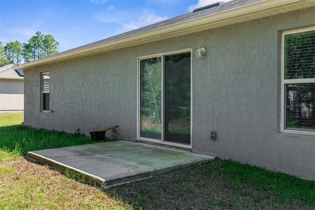 view of side of property featuring a patio area and stucco siding