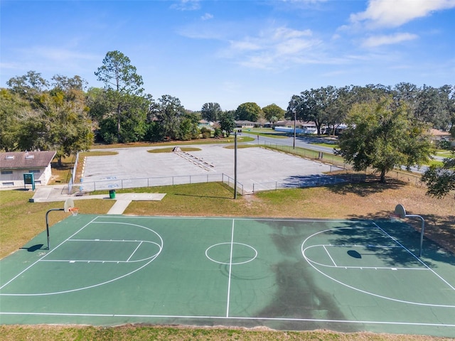view of sport court featuring community basketball court, fence, and a yard