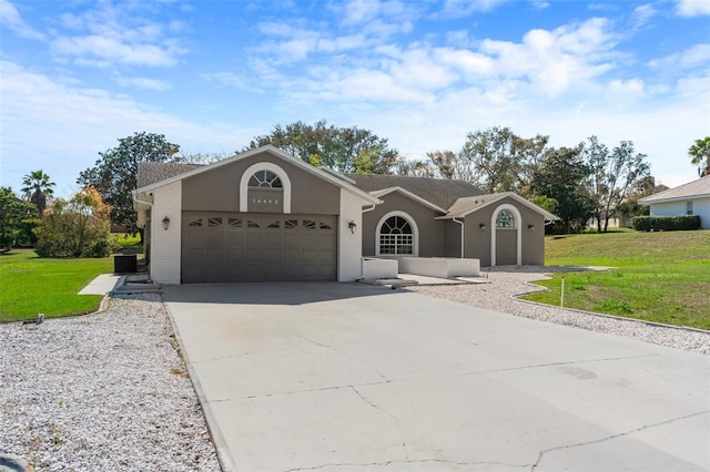 ranch-style home featuring concrete driveway, brick siding, an attached garage, and a front yard