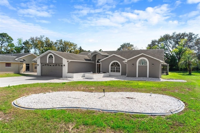 back of property featuring driveway, an attached garage, a lawn, and stucco siding