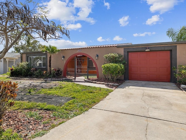 mediterranean / spanish-style home featuring driveway, an attached garage, and stucco siding