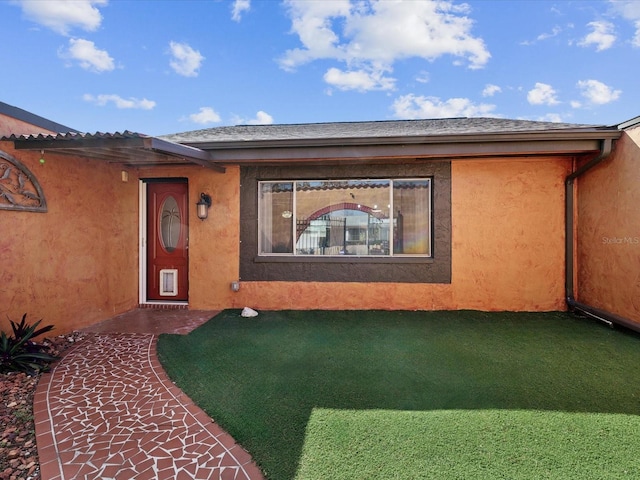 doorway to property featuring a shingled roof and stucco siding