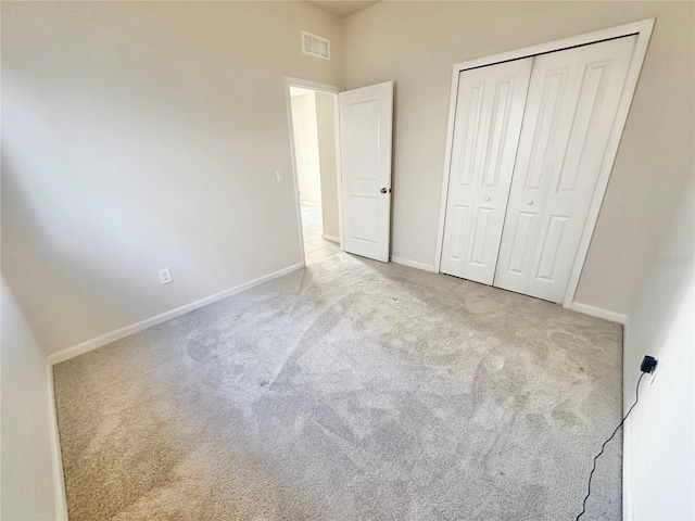 unfurnished bedroom with baseboards, a closet, visible vents, and carpet flooring