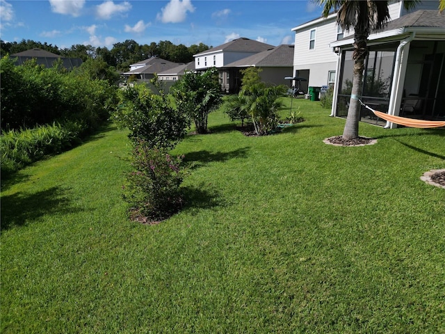 view of yard with a residential view and a sunroom