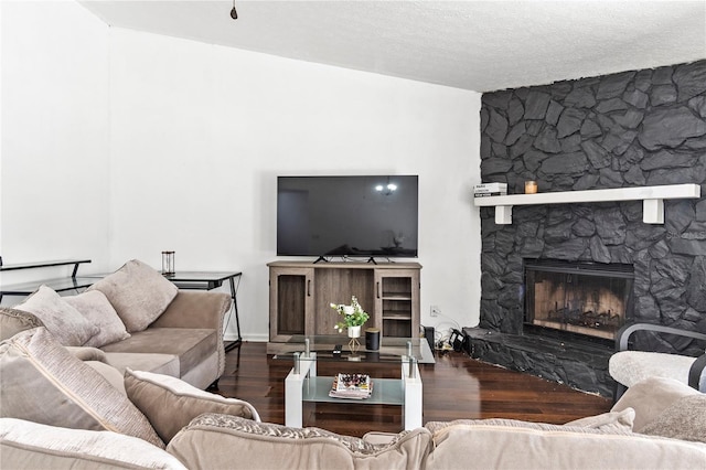 living area featuring a textured ceiling, a fireplace, and wood finished floors