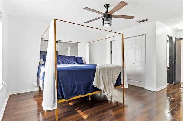 bedroom with a textured ceiling, ceiling fan, wood finished floors, visible vents, and baseboards