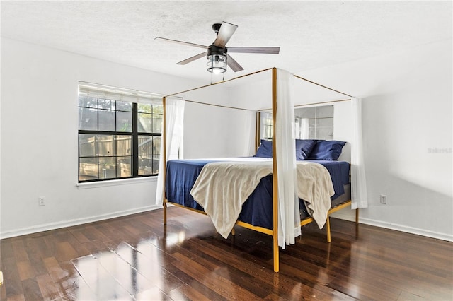 bedroom with a textured ceiling, ceiling fan, wood finished floors, and baseboards