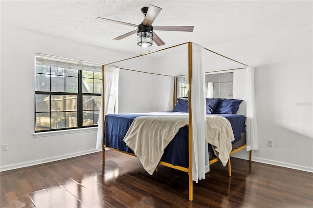 bedroom featuring a ceiling fan, a textured ceiling, baseboards, and wood finished floors