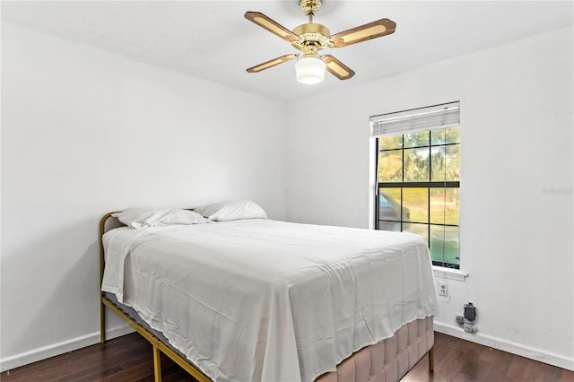 bedroom with a ceiling fan, baseboards, and wood finished floors