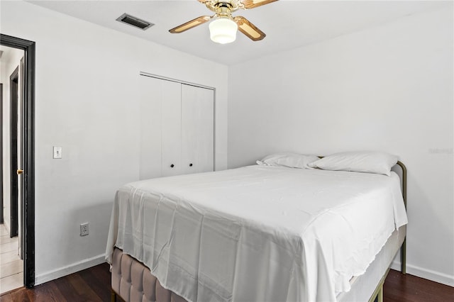 bedroom featuring a closet, visible vents, baseboards, and wood finished floors