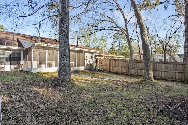 view of yard featuring a sunroom and fence