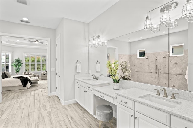 3130 Forsythia Dr, Odessa, FL 33556 - ensuite bathroom featuring double vanity, a walk in shower, a ceiling fan, wood finished floors, and a chandelier