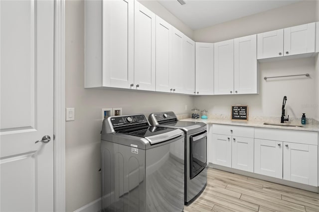 3130 Forsythia Dr, Odessa, FL 33556 - washroom featuring washer and dryer, light wood-style floors, and cabinet space