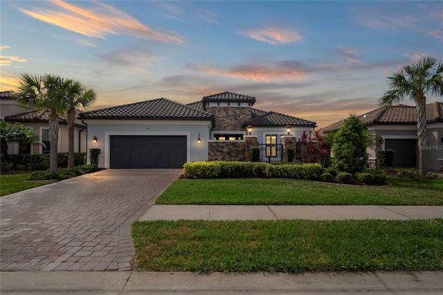 3130 Forsythia Dr, Odessa, FL 33556 - mediterranean / spanish-style home with stucco siding, decorative driveway, a garage, stone siding, and a tile roof