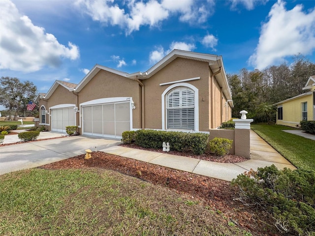 view of front of property with a garage, driveway, and stucco siding