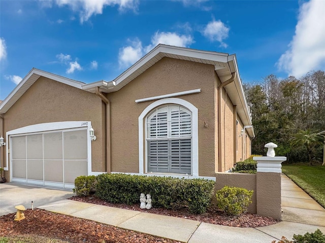 view of home's exterior featuring a garage, concrete driveway, and stucco siding