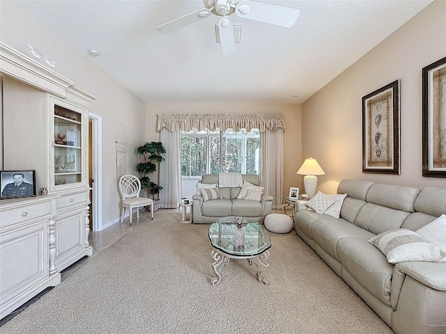 living area featuring ceiling fan, a textured ceiling, and baseboards