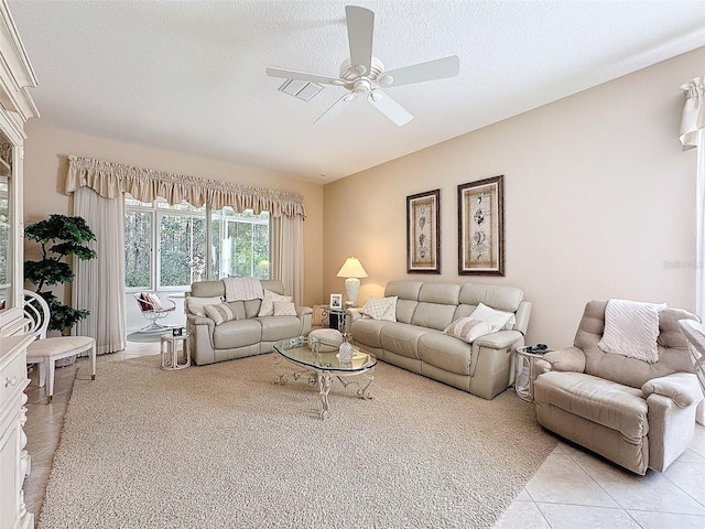 living area featuring light tile patterned floors, a textured ceiling, and a ceiling fan