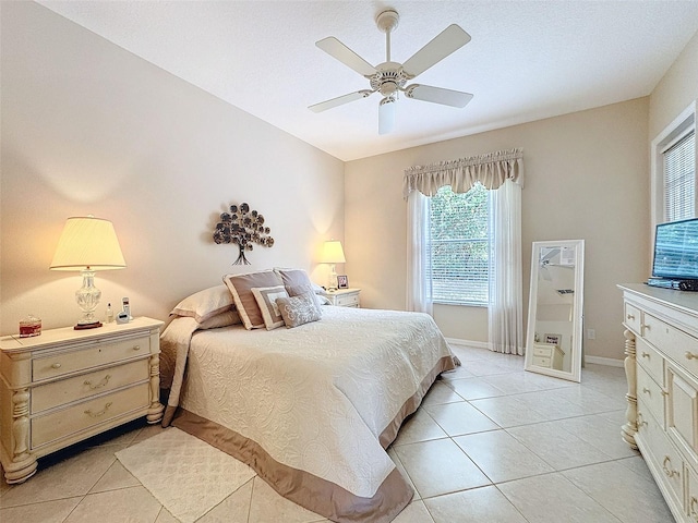 bedroom featuring ceiling fan, light tile patterned flooring, and baseboards