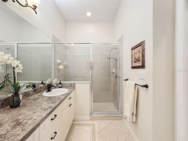 full bathroom featuring baseboards, a shower stall, vanity, and tile patterned floors