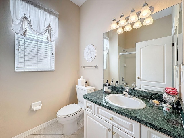 bathroom with tile patterned flooring, toilet, vanity, baseboards, and a stall shower